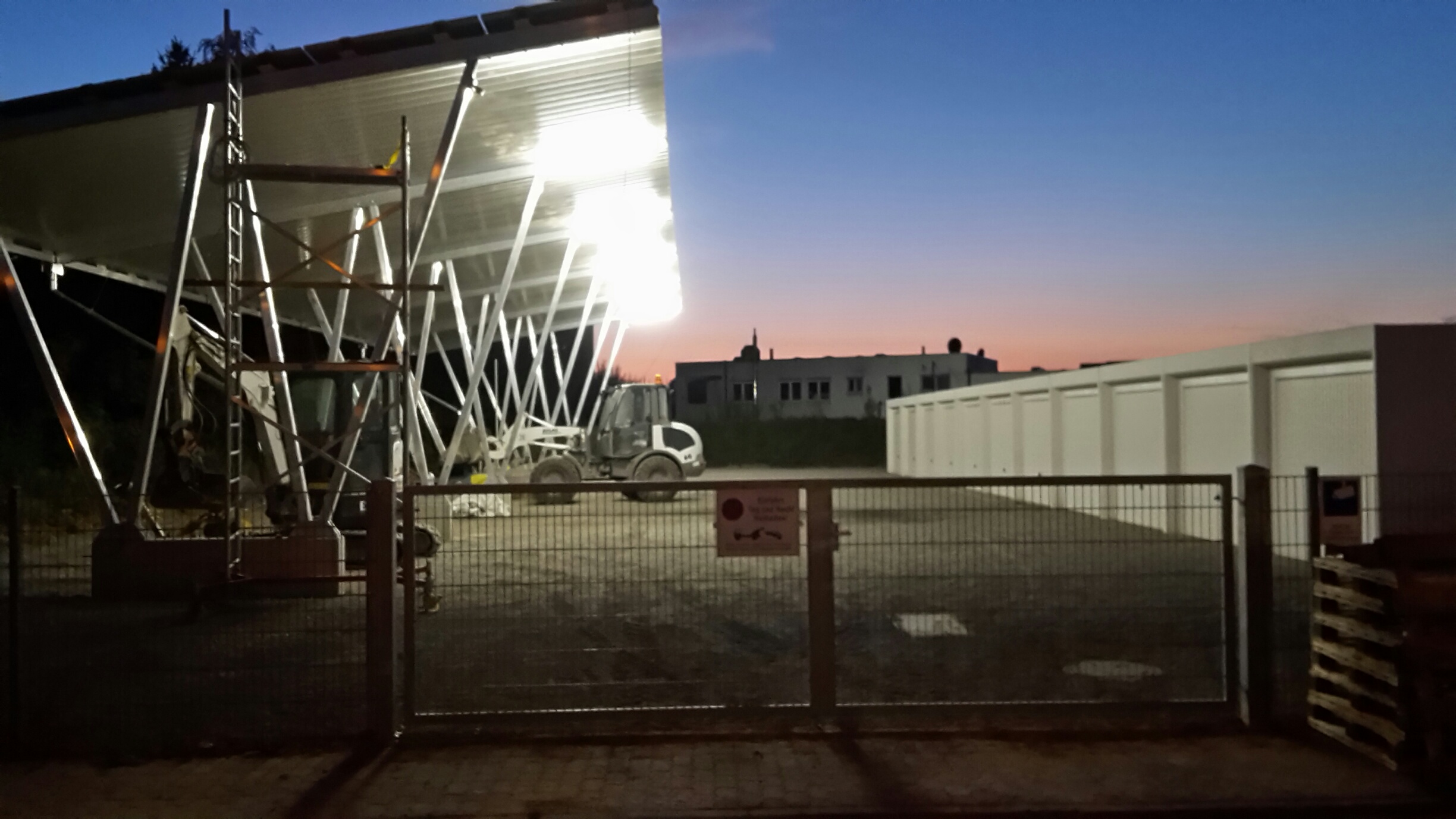 Beleuchtete Stellplatzanlage in der Abenddämmerung