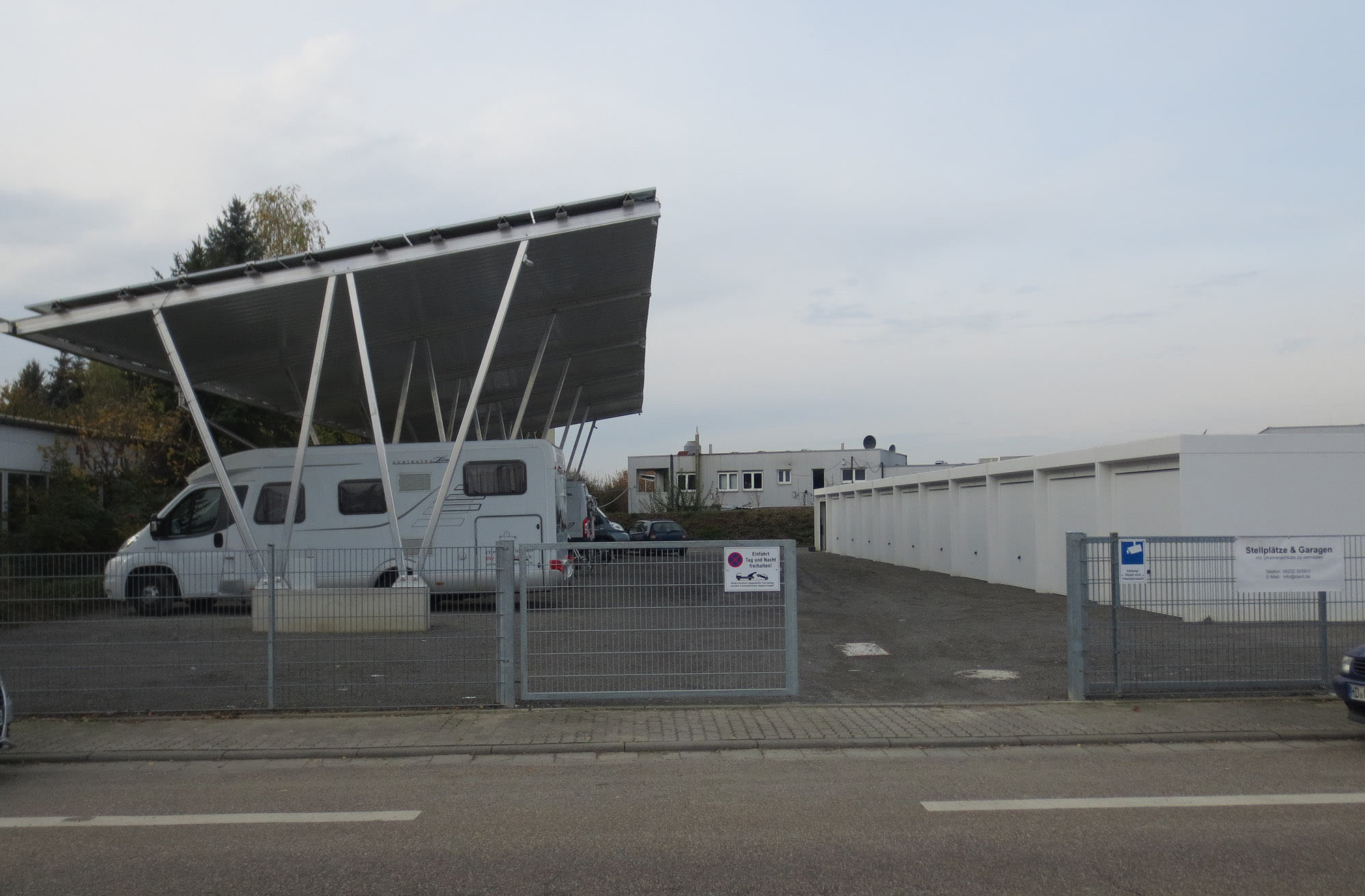 Überdachter Carport-Stellplatz mit Wohnmobil neben der Garagenanlage